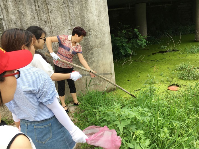 集团公司妇联副主席周海燕带领大家清理江水中的垃圾.jpg